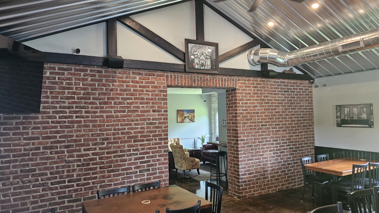 Exposed brick wall and timber roof structure inside The Sip Craft Beer Pub