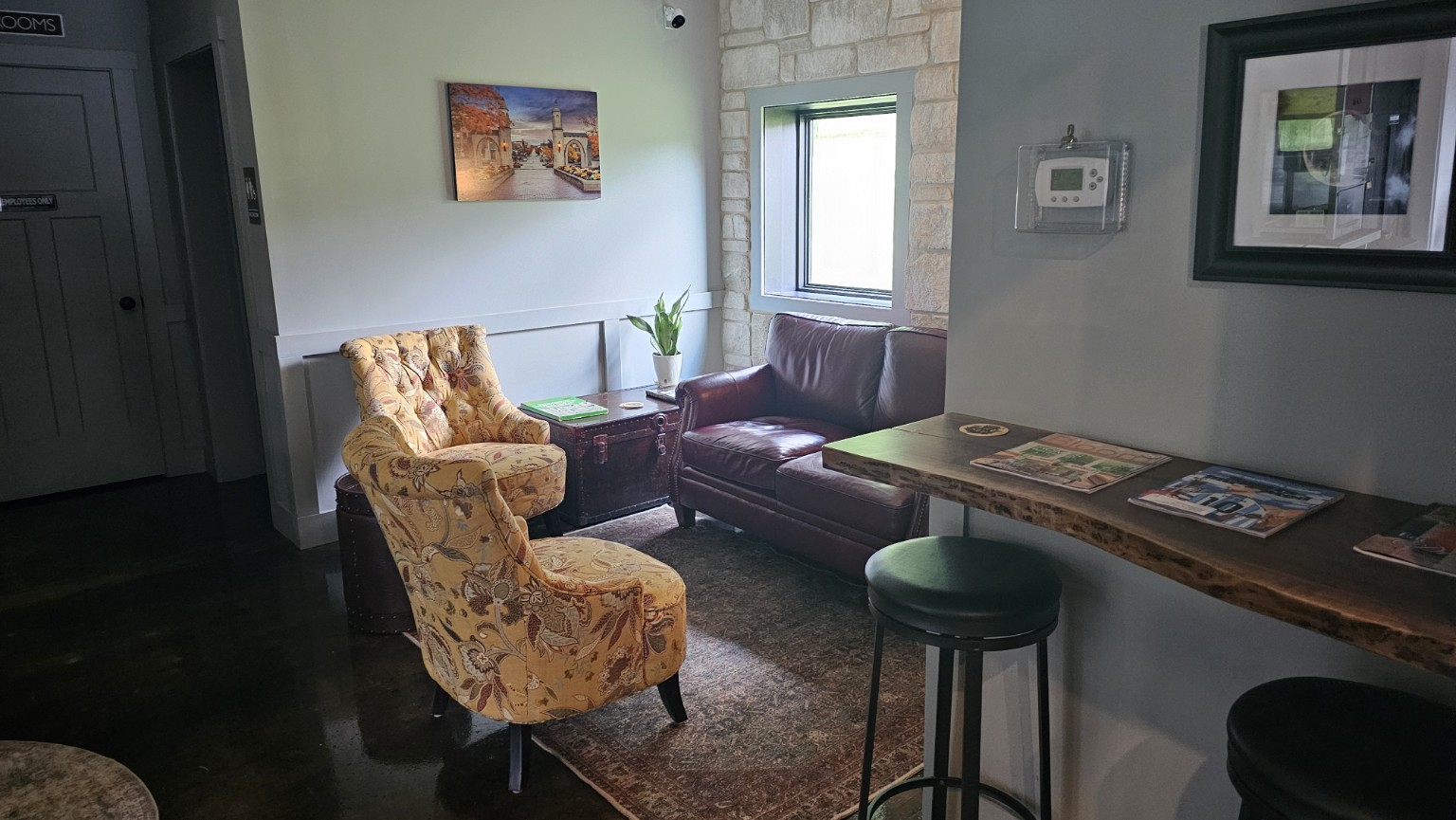 Cozy lounge seating with chairs and side table inside The Sip Craft Beer Pub