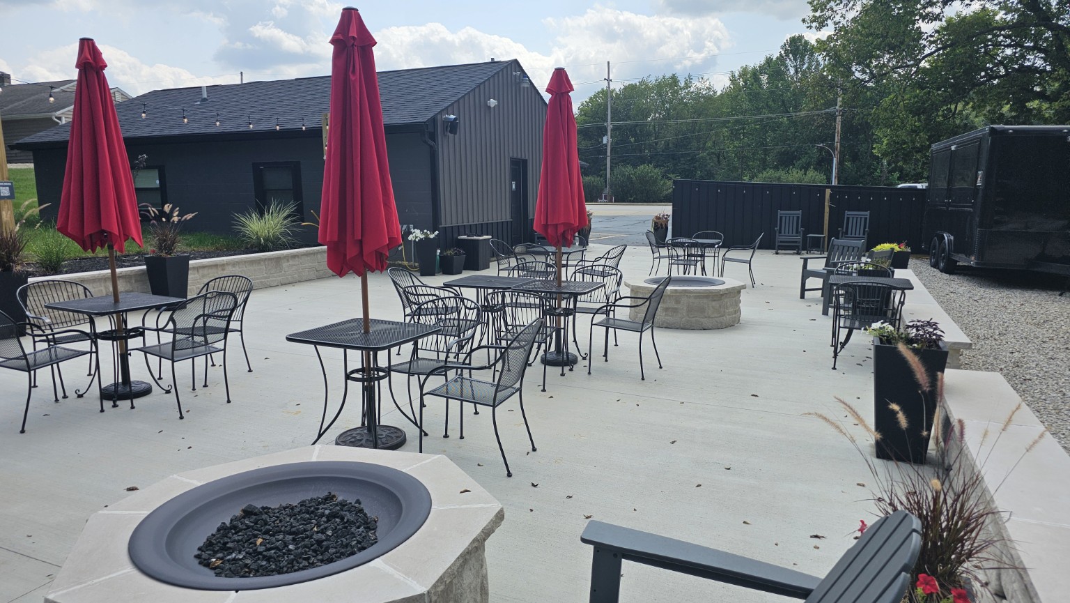 Stone fire pits and outdoor seating on the patio at The Sip Craft Beer Pub