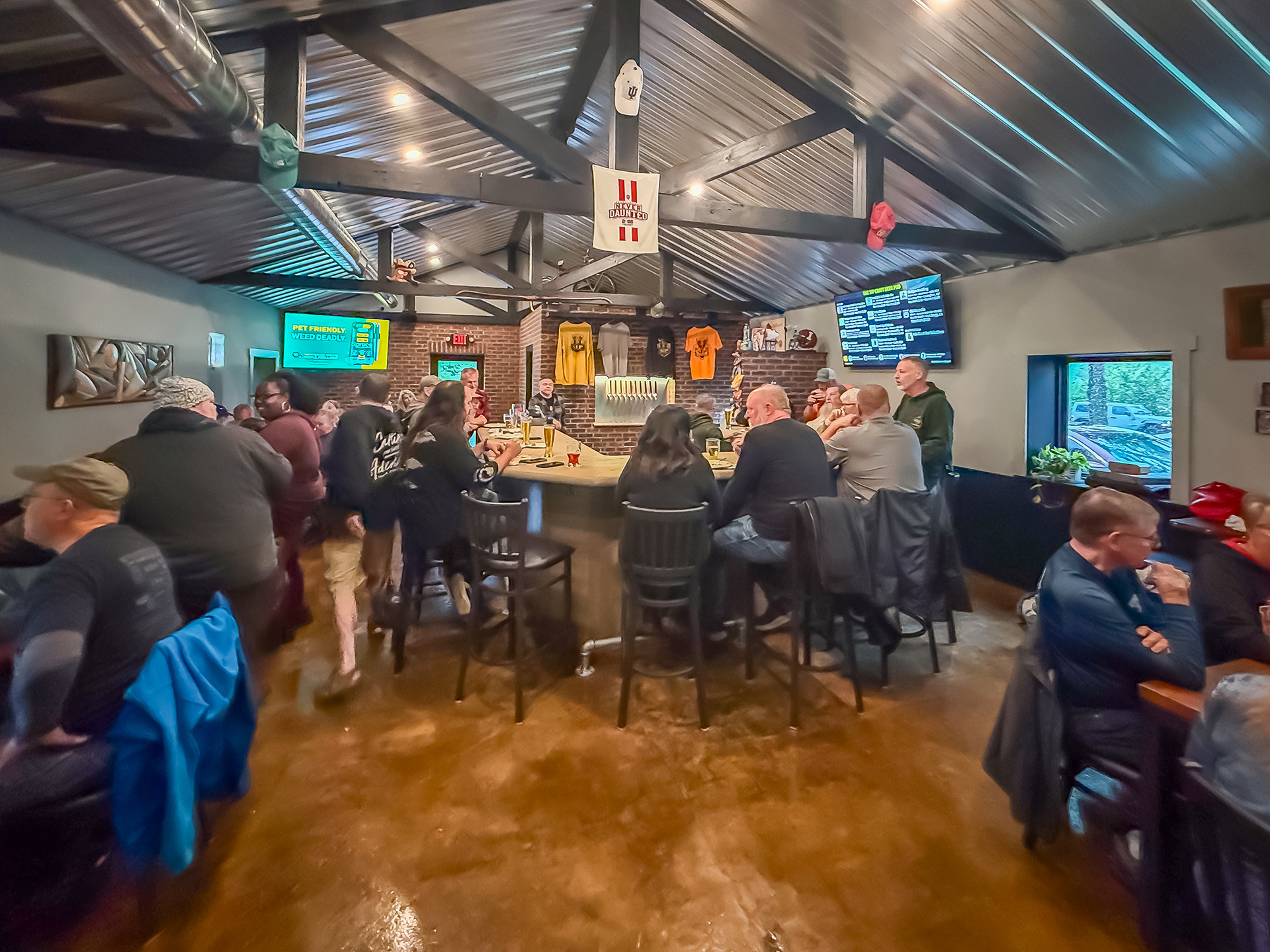 Busy evening inside The Sip Craft Beer Pub with guests seated around the bar